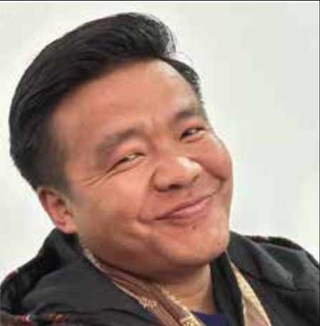 Nima Nima gives a warm smile looking over his shoulder.