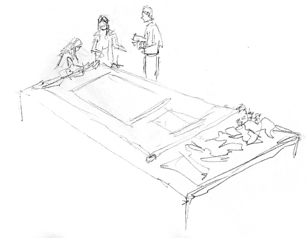 A pencil sketch shows a long table with fabric bundles and a thangka, three figures lean over the end of the table to inspect something